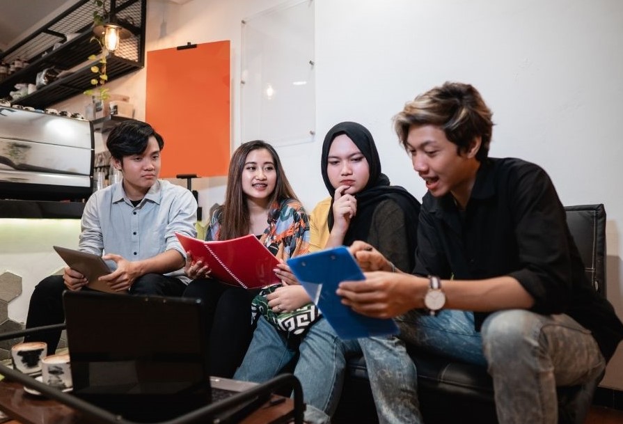 group of teenagers studying and chatting together