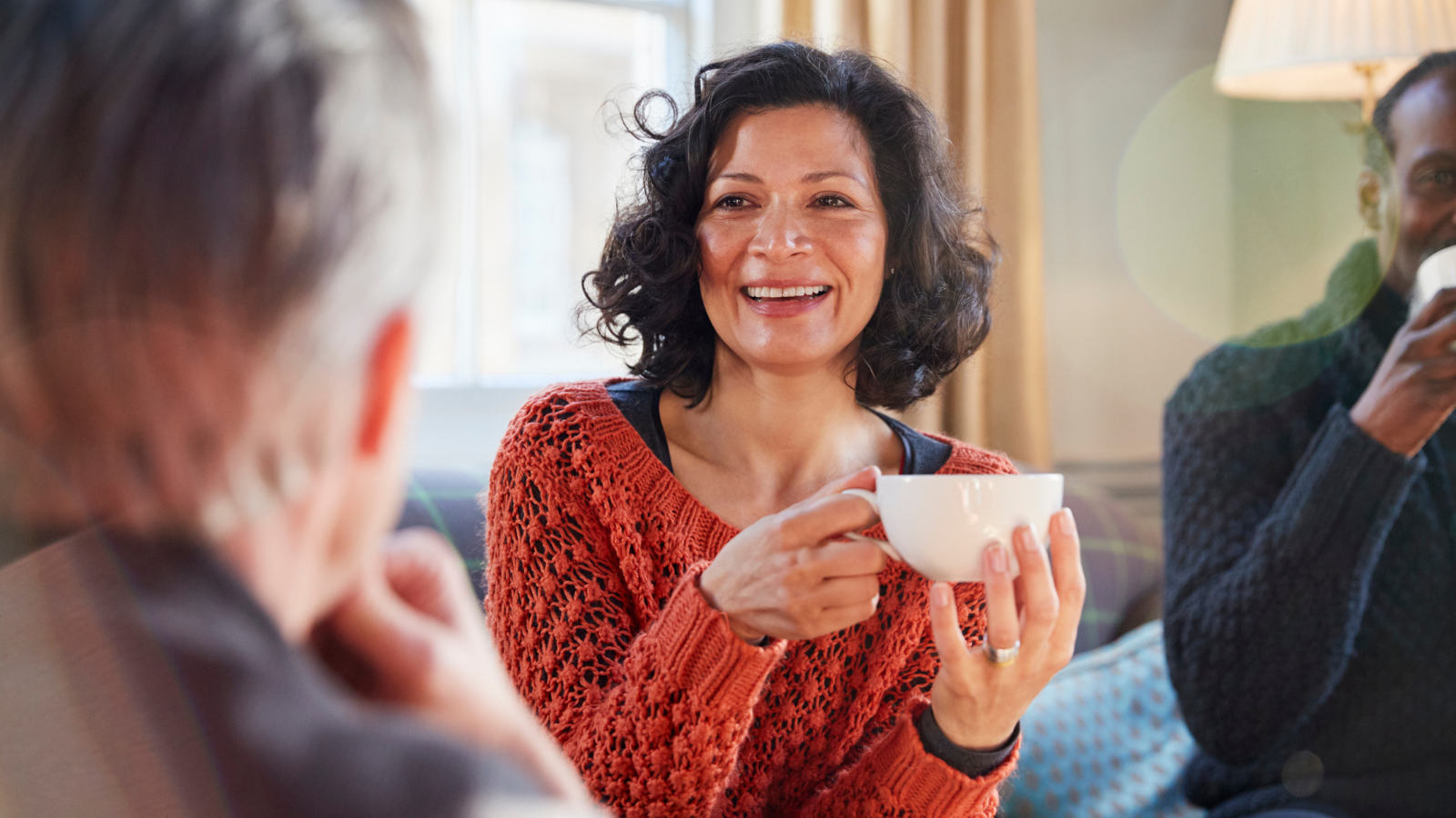 A woman chatting and enjoying coffee with others