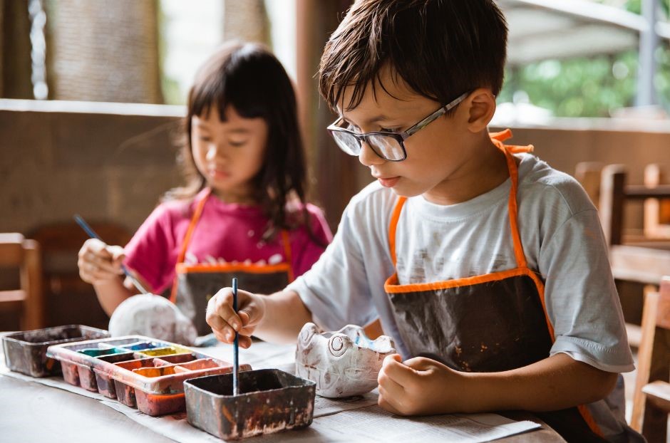 A little girl and boy mixing ingredients in a bowl