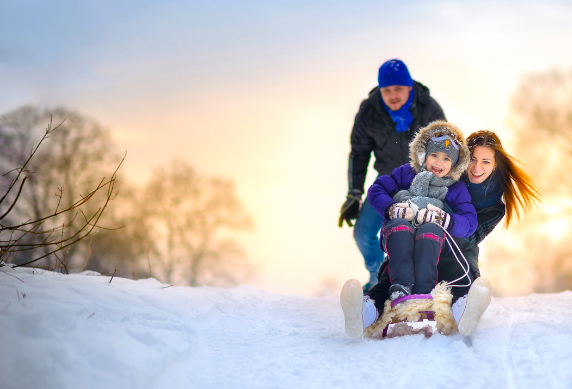 A family enjoying some sledging in the snow