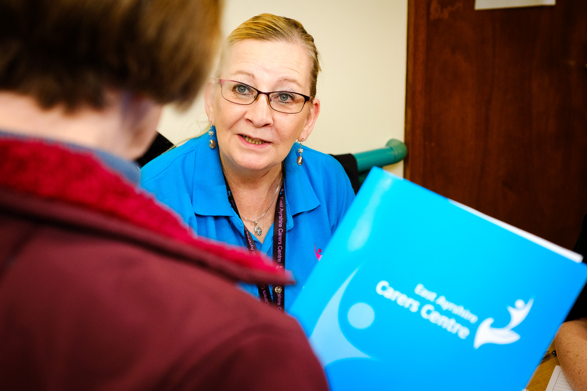 Person speaking to Carers Centre staff at an information stall