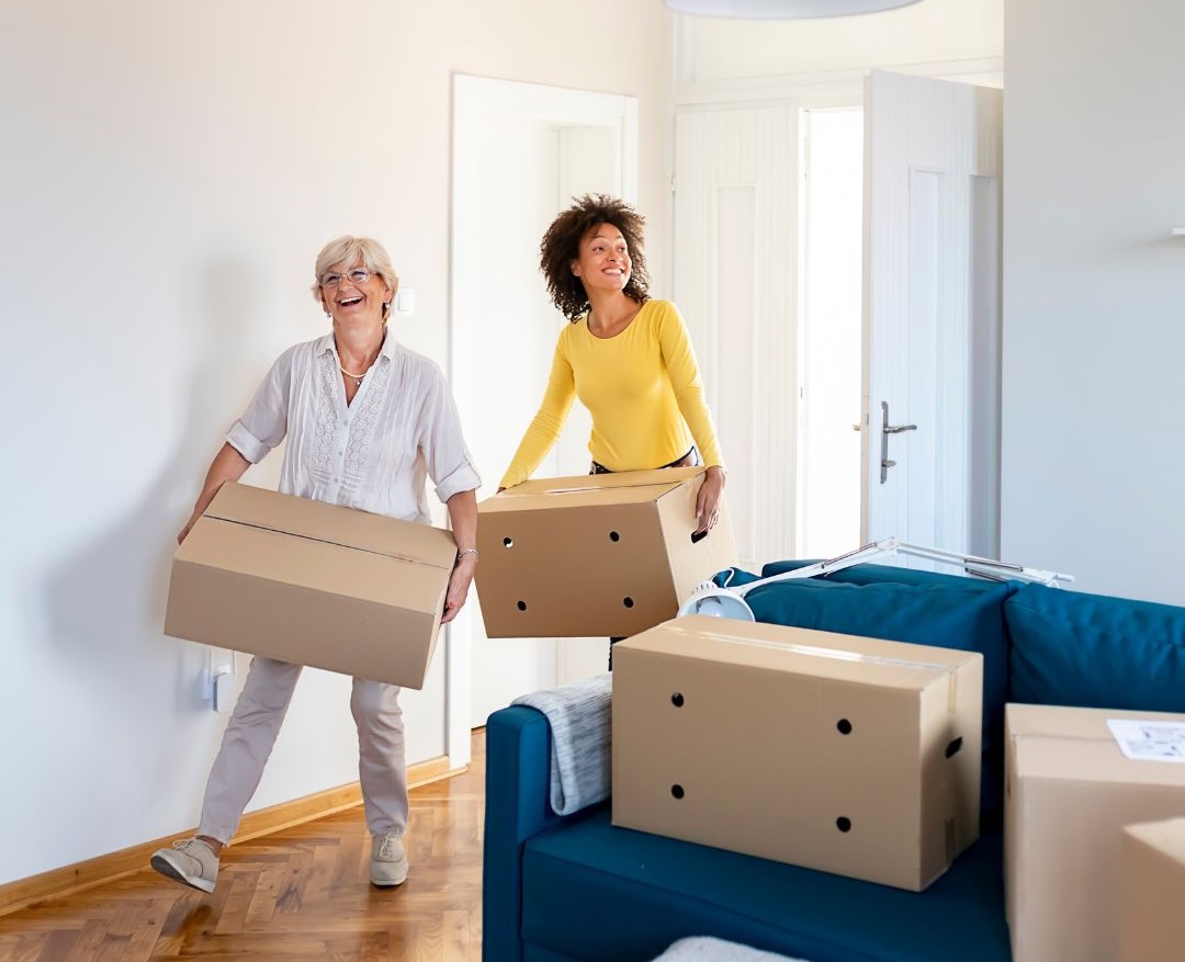 An elderly woman helping a young woman move house.