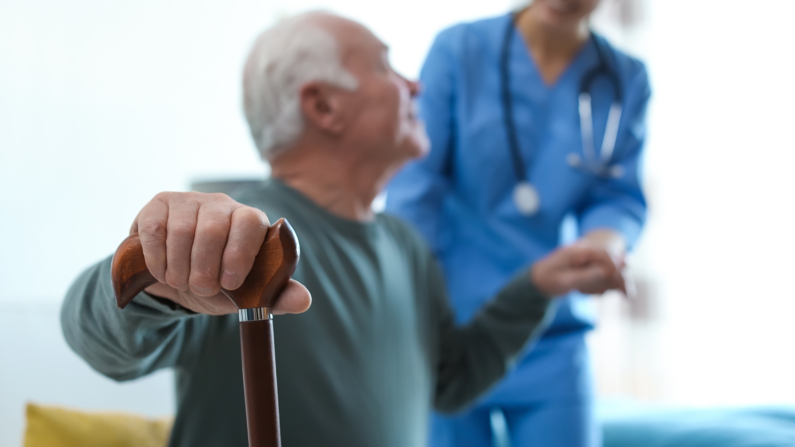 Female care worker helping an elderly gentleman
